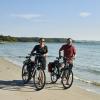 People walking on beach with their bikes on Djursland, East Jutland