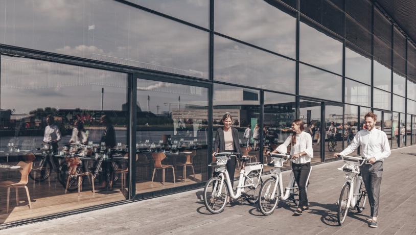 People walking outside the Royal Danish Playhouse "Skuespilhuset" with city bikes, Copenhagen