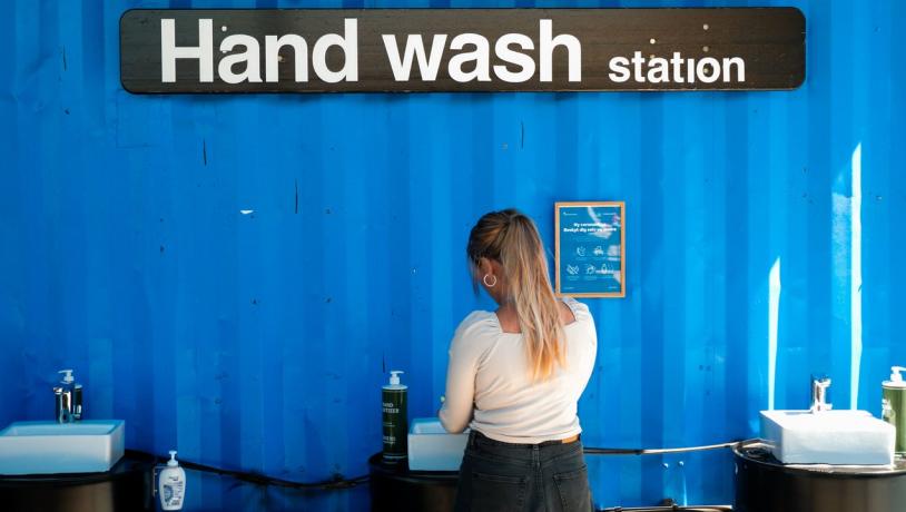 A woman washes her hands at a coronavirus handwash station