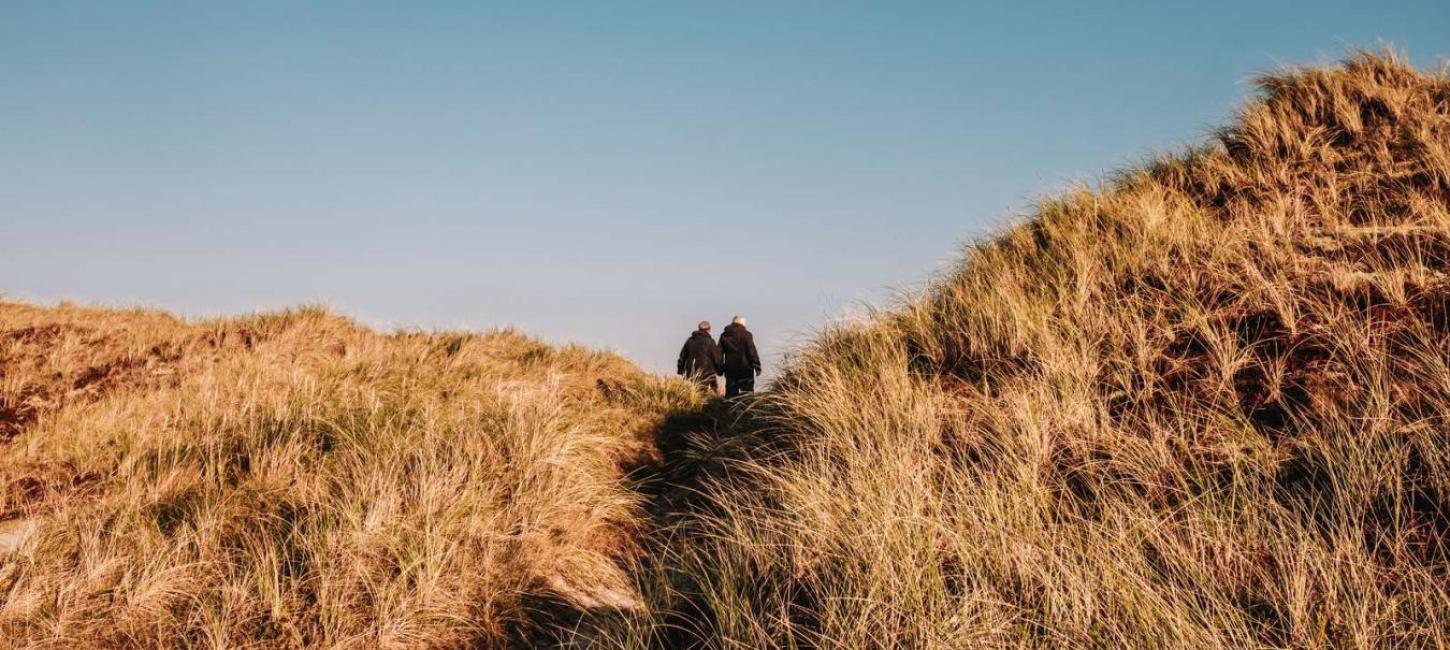 Paar macht einen Herbstspaziergang in den Dünen an der Dänischen Nordsee