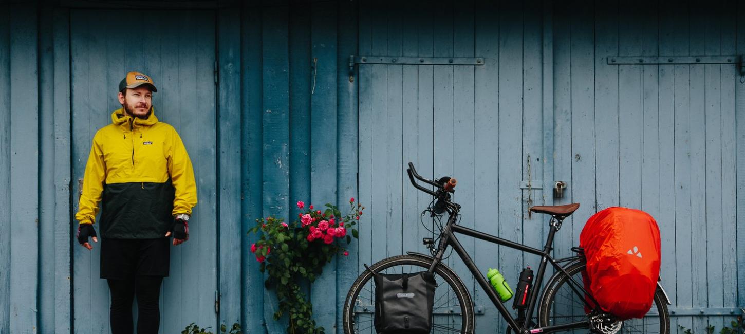 Mann mit gepacktem Fahrrad vor einem Haus auf dem Dänischen Ostseeradweg in Südjütland