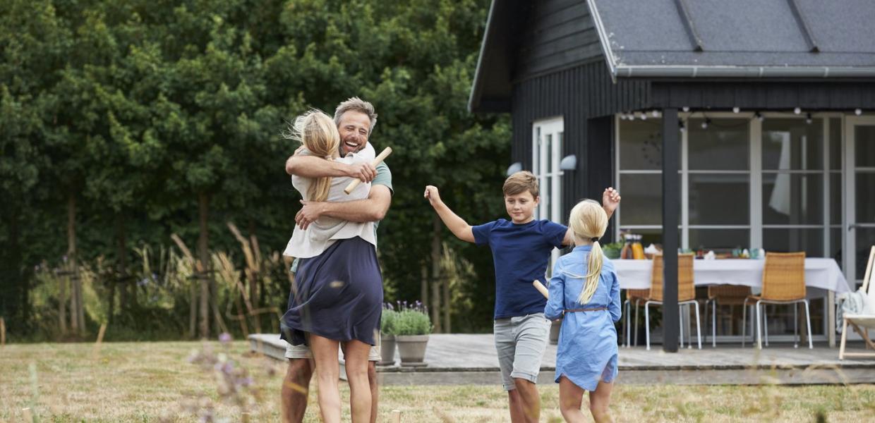Familie vor Sommerhaus in Dänemark