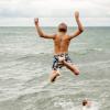 Children jumping into the water at Gilleleje Beach in North Zealand, Denmark