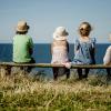 Four children sitting on a bench in Hanstholm, North Jutland, looking at the ocean.