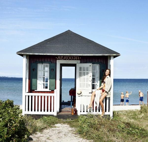 A lady sits at a beach house on Ærøskøbing Beach, Ærø, Denmark