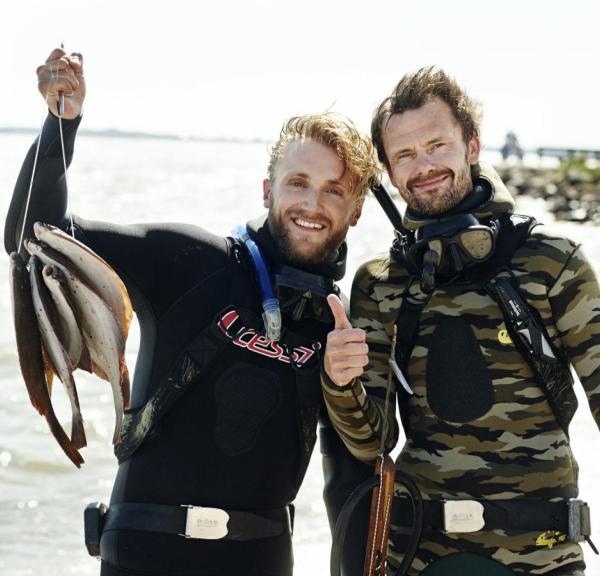 Two men harpoon fishing at Tåsinge, Denmark