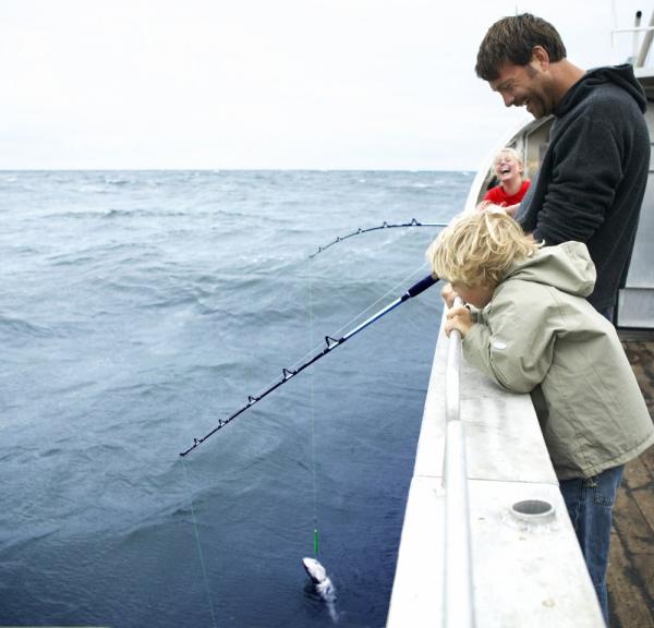 Family fishing from a boat in Denmark