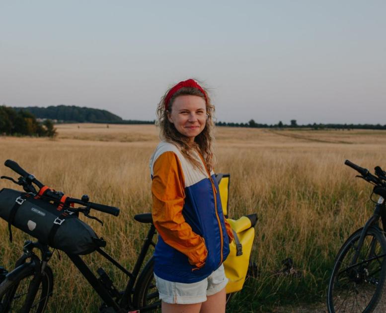 A lady stands with a bike in Hindsgavl National Park, Denmark