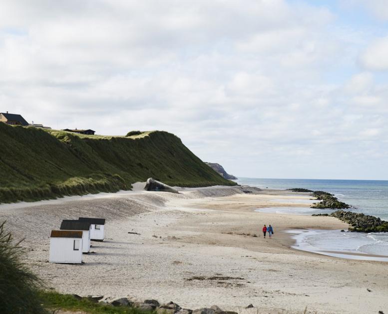 Wandelaars wandelen op het strand van Løkken in Noord-Jutland, Denemarken