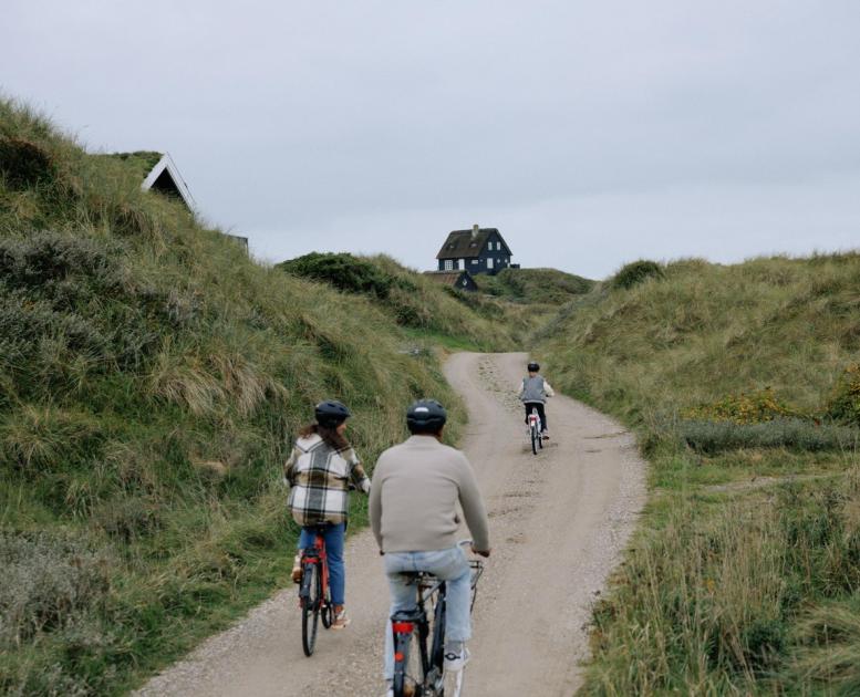 Family cycling to their holiday house at the Danish coast 