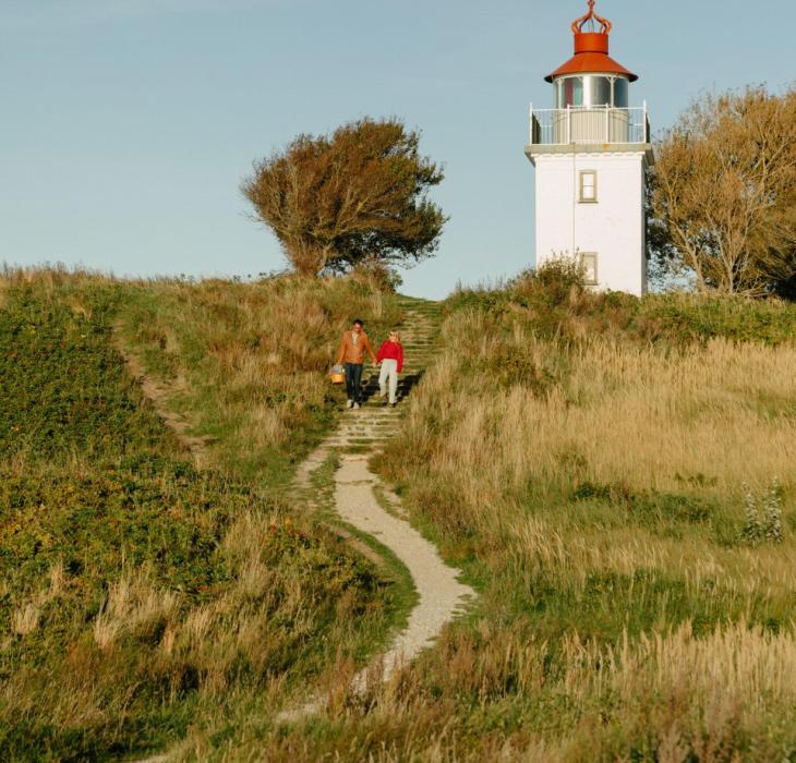 Couple hiking near Spodsbjerg Lighthouse on the Danish coast 
